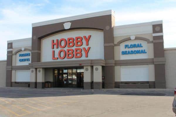 The front entrance of a Hobby Lobby store in New Hampshire with nearby electrical contractors and parking.